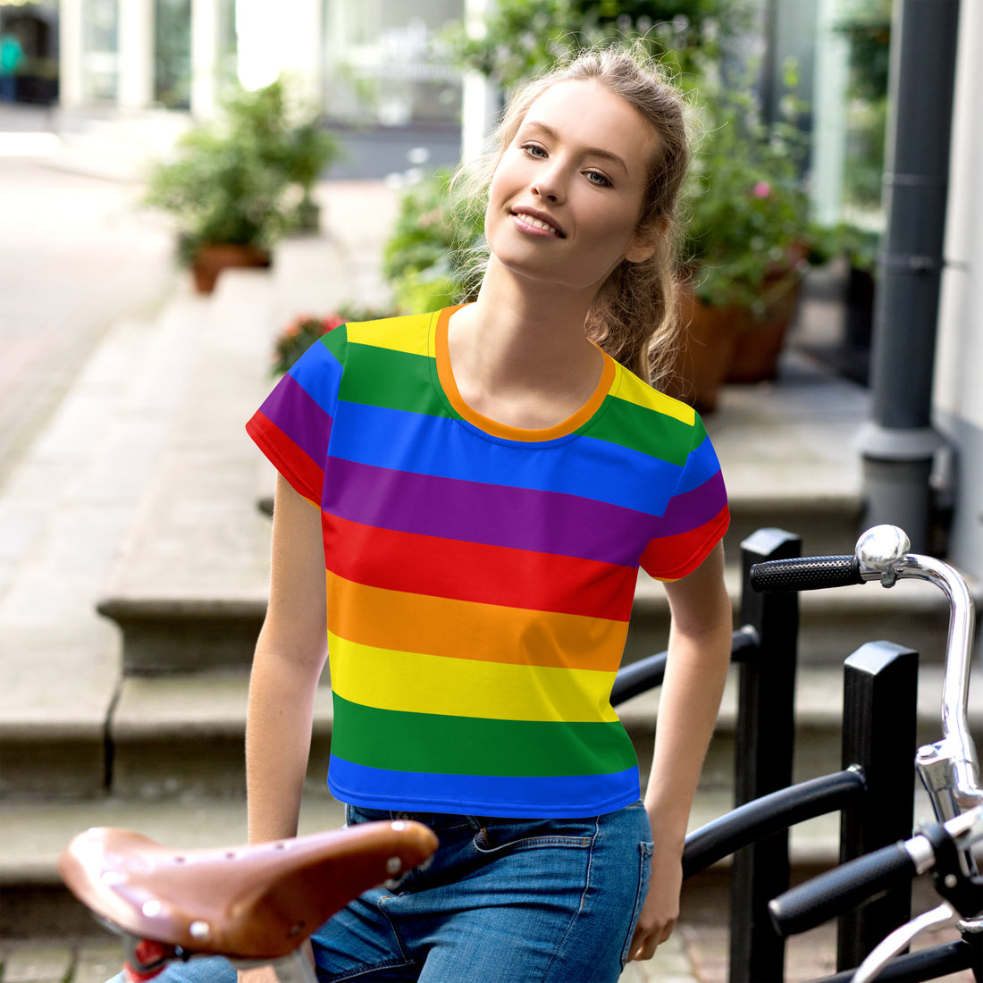 Rainbow Pride Crop Tee with vibrant rainbow stripes displayed on a neutral, studio-style background. The tee features a cropped cut and a bold Pride design, symbolizing LGBTQ+ inclusivity and celebration. Perfect for casual and pride-themed outfits.